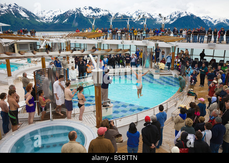 Woman in bikini saute dans une piscine glacée à rejoindre Polar Bear Club alors que les croisiéristes emmitouflés dans des manteaux watch Banque D'Images