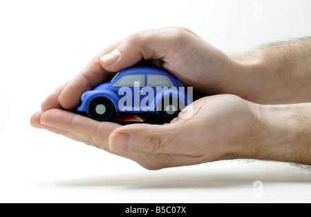 Un modèle voiture couvert et protégé par un homme de main. RE ASSURANCE AUTO ACCIDENT SÉCURITÉ PROTECTION PRIMES MOTORING FAMILLE LAPIN UK Banque D'Images