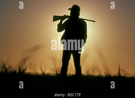 Un chasseur de faisan avec un fusil de calibre 12, marche le pays des prairies de l'est du Mexique, près de la ville de Clovis Banque D'Images