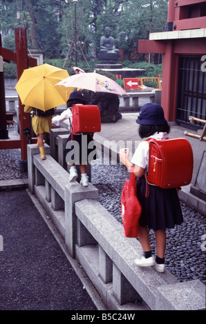 Les écolières japonaises walking in park avec parasols Banque D'Images