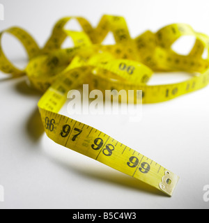 Mètre-ruban jaune, 97 98 99 pouces, démêlé, sur fond blanc. Banque D'Images