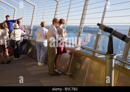 Couple stand Romantique ensemble pendant que le guide parle aux visiteurs sur le pont d'observation de la Space Needle de Seattle, WA Banque D'Images