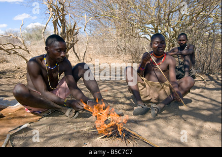 Les hommes Hadza plier une flèche de chasse sur un feu Lake Eyasi Tanzanie Banque D'Images