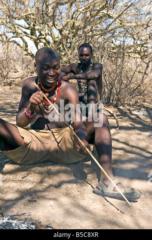 Les hommes Hadza plier une flèche de chasse Lake Eyasi Tanzanie Banque D'Images