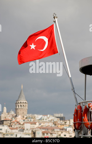 Drapeau turc sur l'arrière d'un bateau avec la tour de Galata en arrière-plan, Istanbul Turquie Banque D'Images