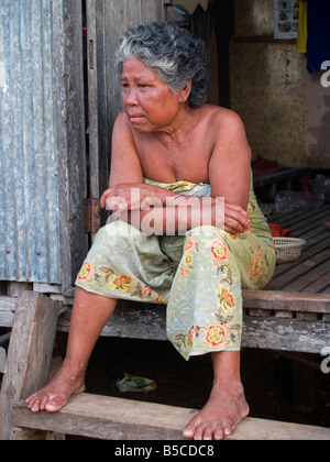 Sea Gypsy femme assise en face de sa maison à la plage de Rawai à Phuket Thaïlande Banque D'Images