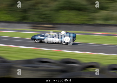 Une vitesse d'obturation lente panoramique d'une vieille voiture classique à Oulton Park dans le Cheshire en Angleterre. Banque D'Images