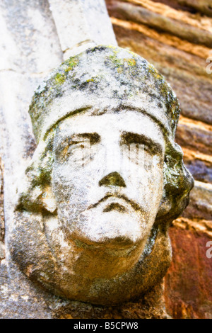 Une sculpture représentant un des saints chrétiens, probablement Saint Pierre, sur le mur d'une église de village rural. UK. Banque D'Images