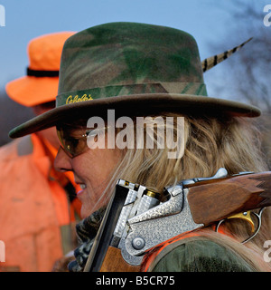 Femme de la sportive avec fusil de chasse au faisan pendant sur Kansas Farm Banque D'Images