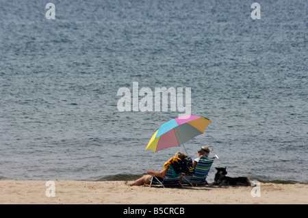 Deux femmes se détendre sur la plage du Lac Michigan avec leur chien Grand Haven Michigan Banque D'Images