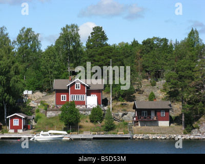 Une image typique de l'archipel de Stockholm avec le falunröd typiques maisons le long de la rive Banque D'Images