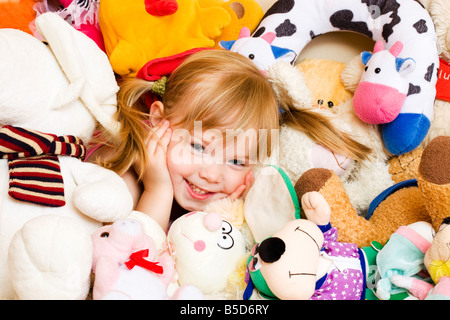 Smiling blonde petite fille, 4 ans, avec des peluches animaux Banque D'Images