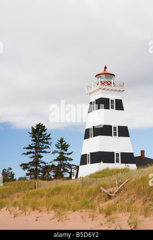 L'herbe pousse le long des dunes en face de la phare de West Point sur la plage sur l'Île du Prince Édouard, Canada. Banque D'Images