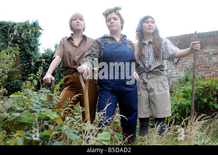 Image libre de photographie de la Women's Land Army in wartime standing in garden à la fière avec 1940 vêtements de style. Banque D'Images