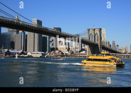 New York Water Taxi qui passe sous le pont de Brooklyn sur l'East River Banque D'Images