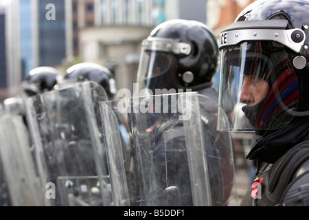 Ligne de service de police PSNI de l'Irlande du Nord Les agents antiémeutes forme une barrière de protection avec boucliers antiémeutes lors de perturbation bel Banque D'Images