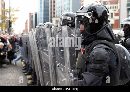 Ligne de service de police PSNI de l'Irlande du Nord Les agents antiémeutes forme une barrière de protection avec boucliers antiémeutes lors de perturbation Banque D'Images