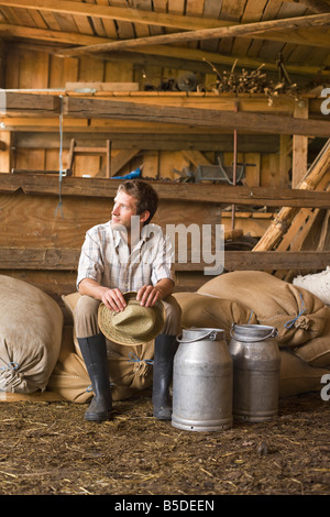 Farmer sitting in barn Banque D'Images