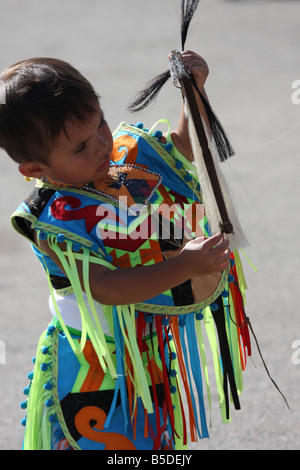 Une jeune Native American Indian boy holding a horse whip cheveux plaqués dans un costume de danse lors d'un Pow-wow au Milwaukee Lakefront Banque D'Images