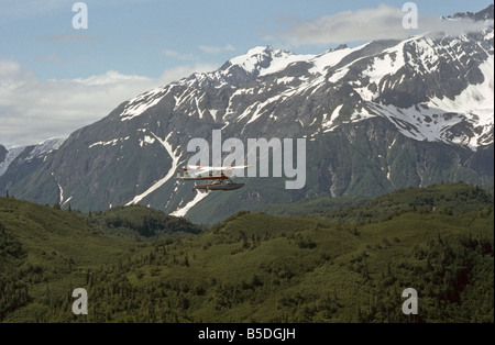 Un hydravion piloté par un pilote de brousse glisse dans la chaîne de l'Alaska transportant des pêcheurs dans un lac de montagne Banque D'Images