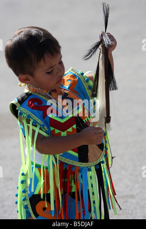 Une jeune Native American Indian boy holding a horse whip cheveux plaqués dans un costume de danse lors d'un Pow-wow au Milwaukee Lakefront Banque D'Images