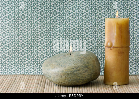 Deux bougies, une rivière en forme et couleur de roche, l'autre en forme de bambou Banque D'Images