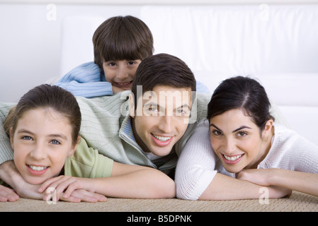 Portrait of smiling family lying together sur marbre, fils couché sur le dos de son père Banque D'Images