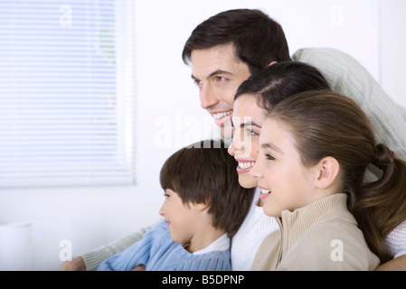 Family smiling at à la voiture ensemble, side view Banque D'Images