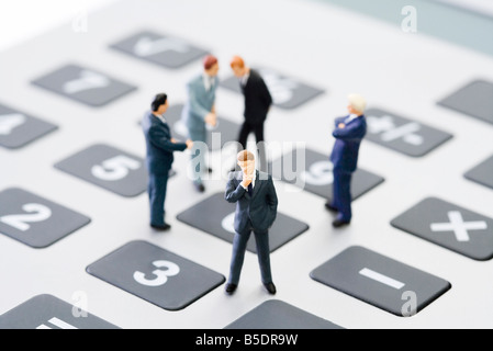 Businessmen standing miniature sur calculatrice Banque D'Images