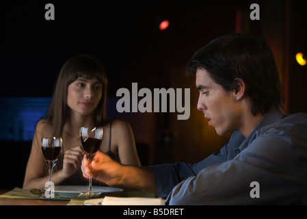 Couple having conversation sérieuse au cours d'un dîner au restaurant, l'homme prendre un verre de vin Banque D'Images