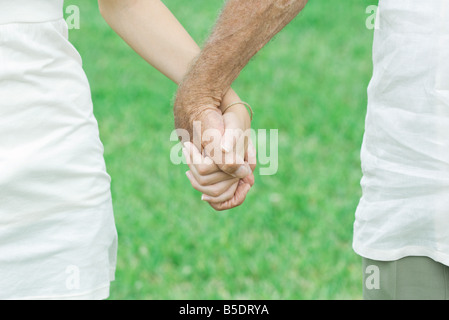 Petite-fille et grand-père holding hands outdoors, portrait Banque D'Images