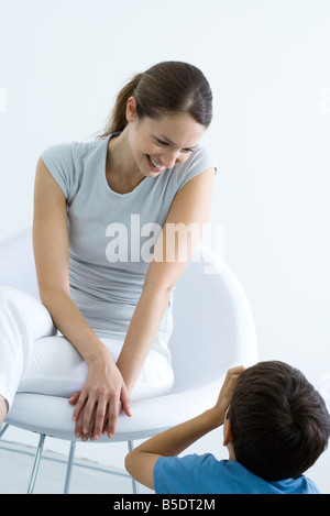 Femme assise dans une chaise, souriant à fils Banque D'Images