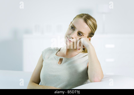 Woman leaning on elbow, looking away Banque D'Images