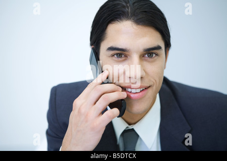 Young man holding cell phone, smiling, portrait Banque D'Images