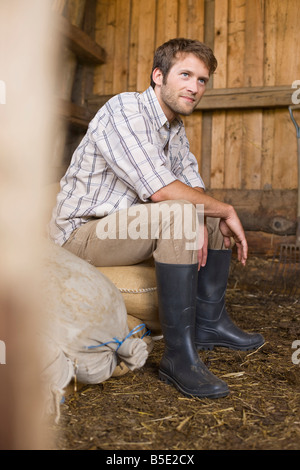 Farmer sitting in barn Banque D'Images