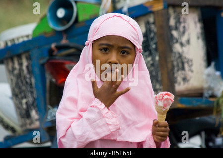 Muslim Girl Eating Ice Cream dans Sapit sur île de Lombok en Indonésie Banque D'Images