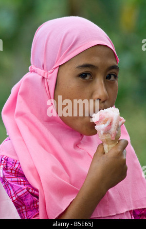 Muslim Girl Eating Ice Cream dans Sapit sur île de Lombok en Indonésie Banque D'Images