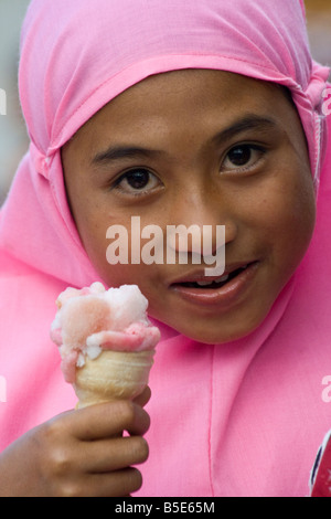 Muslim Girl Eating Ice Cream dans Sapit sur île de Lombok en Indonésie Banque D'Images