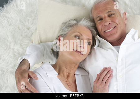 Vieux couple allongé sur un tapis de fourrure Banque D'Images