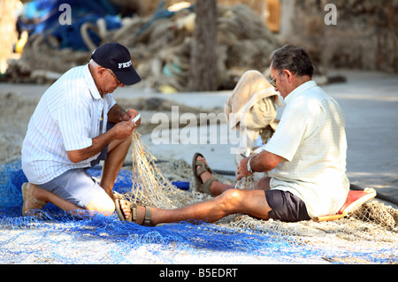 Les pêcheurs de la réparation d'un filet de pêche, Majorque, Espagne Banque D'Images