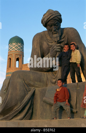 Enfants jouant sur statue de poète ouzbek, Khiva, Ouzbékistan, l'Asie centrale Banque D'Images