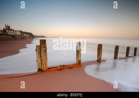 Vague se précipiter sur des éperons de fer sur le front de mer à Teignmouth Devon UK Banque D'Images