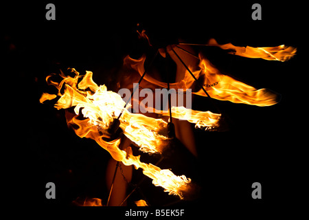 Femme firepoise fire dance performance holding fire fans la nuit effectuer Banque D'Images