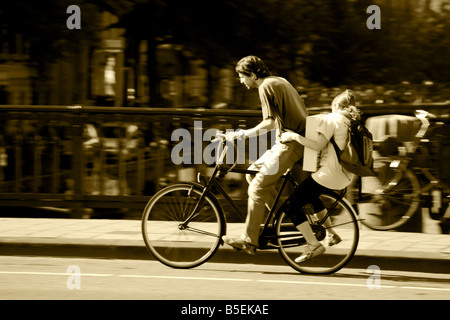 L'homme à vélo avec leurs passagers équitation à Amsterdam Banque D'Images