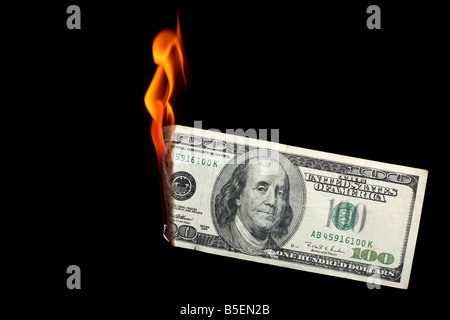 One hundred dollar bill burning sur fond noir Banque D'Images