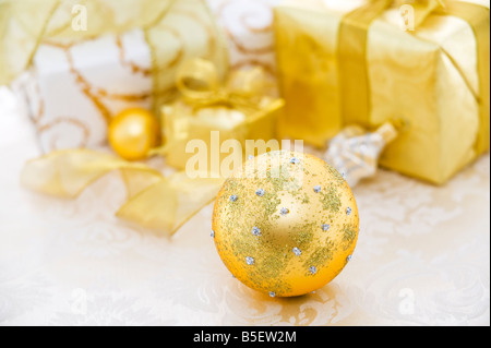 Décoration de Noël blanc et or cadeaux ornements sur une nappe de lin blanc Banque D'Images