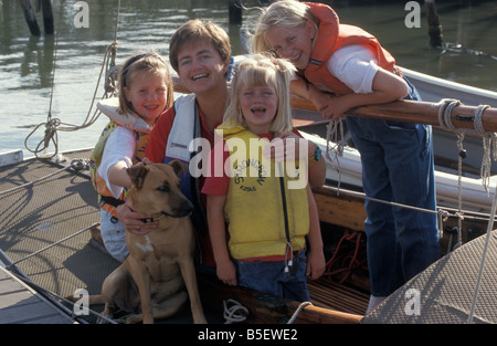 Mère et trois filles posant dans des gilets de sauvetage sur le bateau Banque D'Images