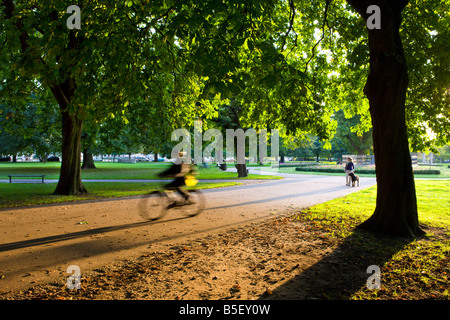 Le cycliste et le chien walker en Watts Park Le centre-ville de Southampton Hampshire Angleterre Banque D'Images