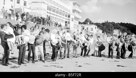 Miel sur le Sunny Isle de Jersey. 140 couples se sont réunis à St Brelades Bay pour un champagne plateau donnée par la tam Night Club. Avant de s'asseoir pour le thé qu'ils se sont réunis en forme de coeur sur le sable pour une photo souvenir. Un certain nombre de couples a leur mariage avant de battre le fisc et le changement dans les couples mariés des abattements fiscaux. Avril 1968;Y3321 ; Banque D'Images