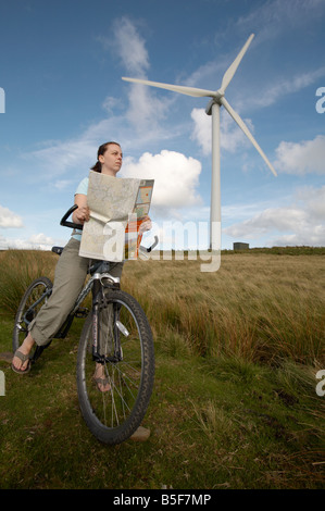 Un cycliste féminin contrôle de l'Ordnance Survey map à un parc éolien sur les landes de la forêt de Bowland dans le Lancashire Banque D'Images